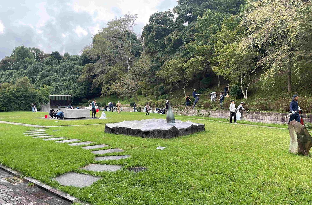 画像：清掃道具を手に中庭を整備する多くの人たち